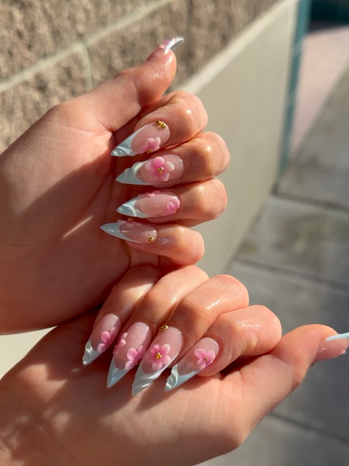 Delicate 3D pink floral nail art on almond-shaped nails with gold accents